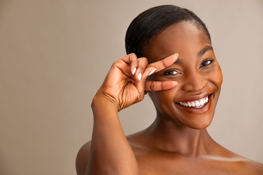 Beauty african woman showing the eye with the fingers