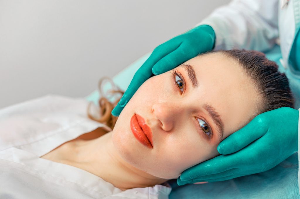 Rhinoplasty, the surgeon hands touches the patient s nose. People, cosmetology, plastic surgery and