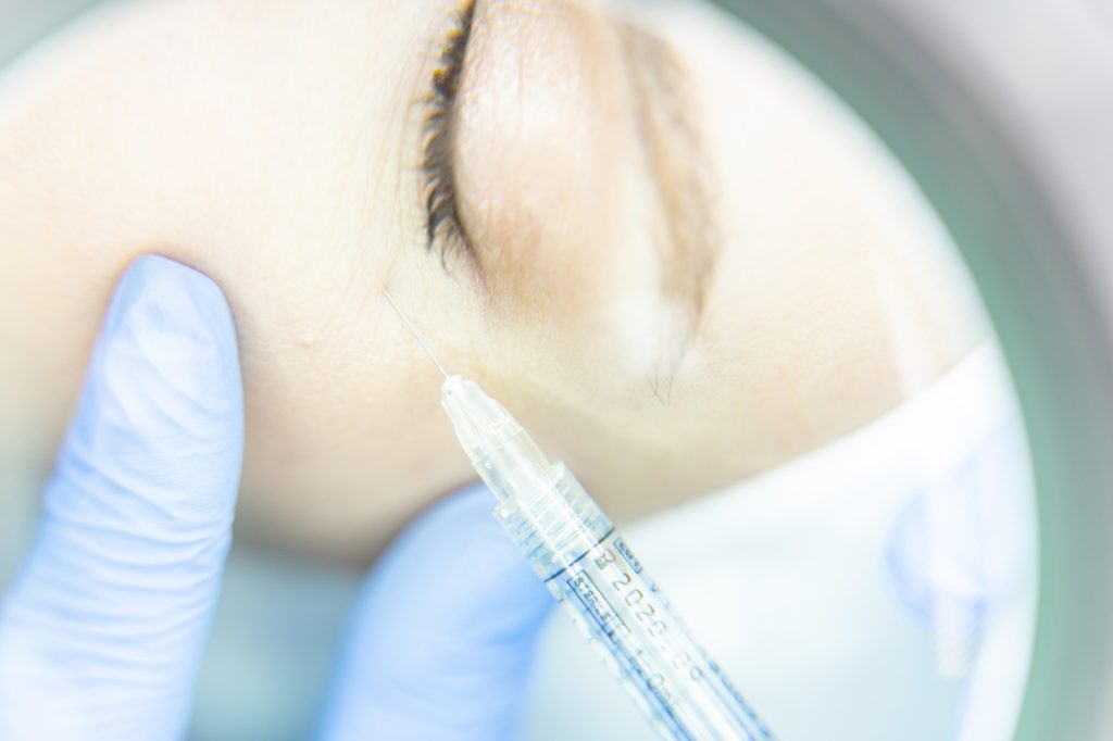 Woman getting an injection into the under-eye area